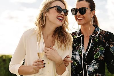 an image depicting two women with champagne glasses laughing