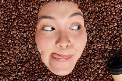 Graphic design showing a woman immersed in coffee beans