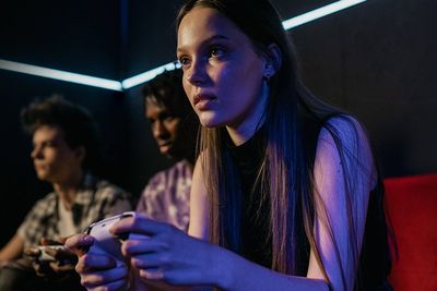 an image of a girl playing videogames with two guys