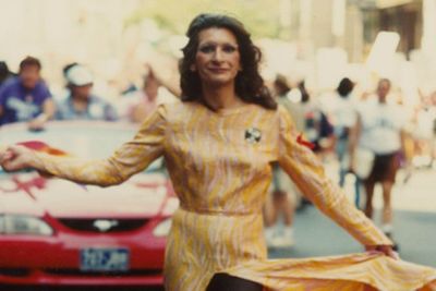 A photograph of Sylvia Rivera in a yellow dress during a march