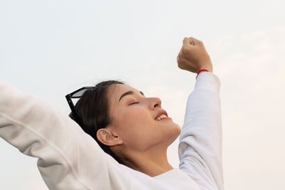 woman stretching her arms to the sky