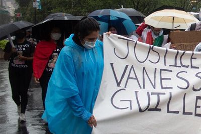 ​A group of protesters hold up a sign reading "Justice for Vanessa Guillen" while marching in the rain