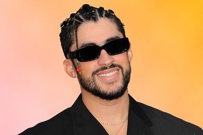Image of the artist Bad Bunny wearing sunglasses in front of a pink and orange ombre background