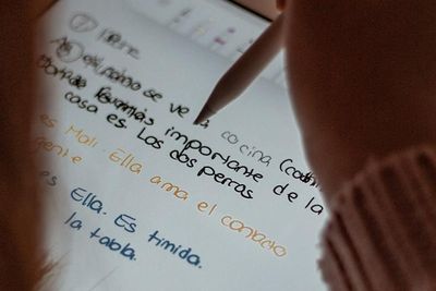 Woman writing sentences in Spanish on an ipad 
