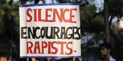 protest sign that reads, "silence encourages rapists"
