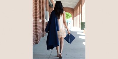 College graduate walking with her cap and gown.