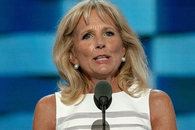 First Lady Jill Biden stands in front of a microphone as she delivers a speech