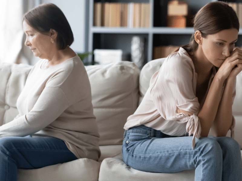 two women sitting facing away from each other